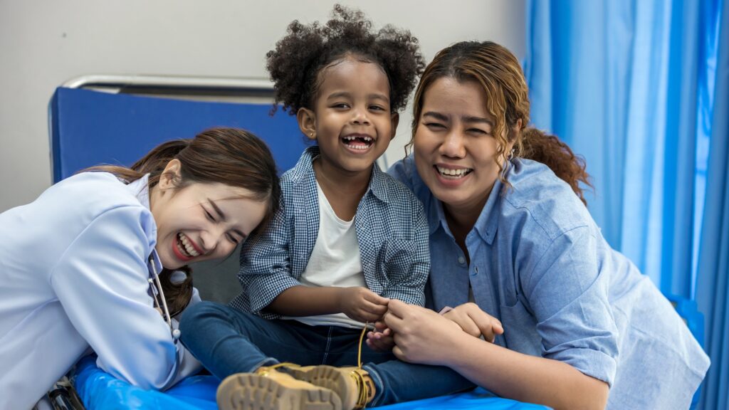 Child having fun on bed in hospital. Little girl and doctor happy in hospital. Hospital Ward: little